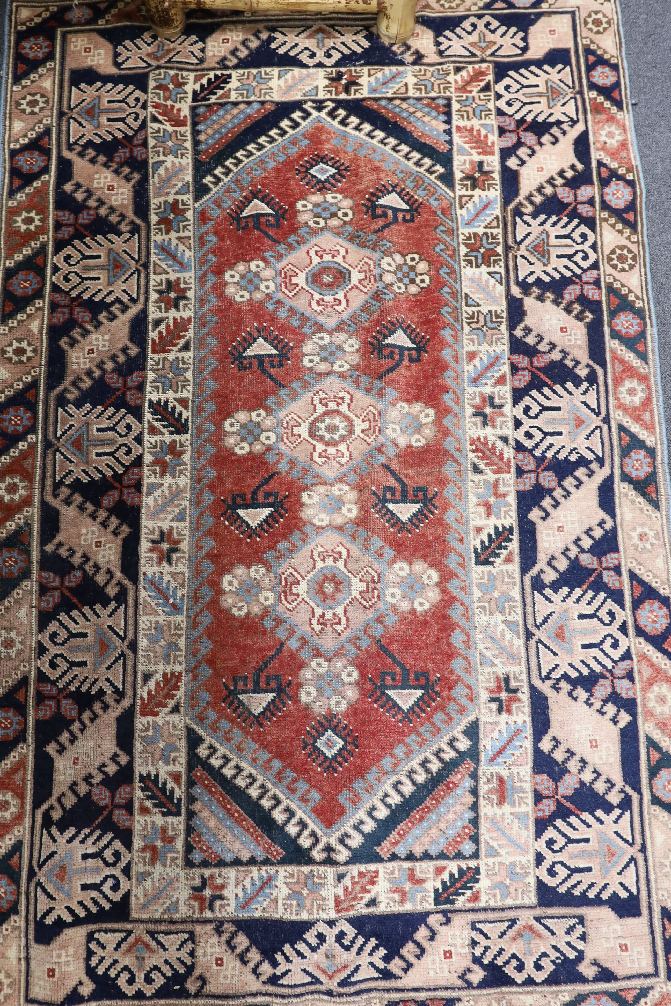 A Caucasian red ground rug and a Bokhara runner, rug 180 x 120 cms